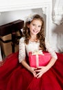 Adorable little girl in princess dress with gift box near firep Royalty Free Stock Photo
