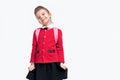 Adorable little girl in red school jacket, black dress, backpack