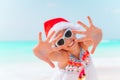 Adorable little girl in Santa hat on tropical beach Royalty Free Stock Photo