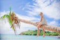 Adorable little girl sitting on palm tree during summer vacation on white beach Royalty Free Stock Photo