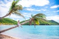 Adorable little girl sitting on palm tree during summer vacation on white beach Royalty Free Stock Photo