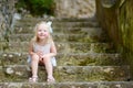 Adorable little girl sitting on stairs on warm and sunny summer day Royalty Free Stock Photo