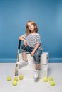 adorable little girl sitting on white boxes with tennis raquet and balls Royalty Free Stock Photo