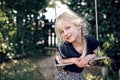 Adorable little girl smiling while playing on a tree swing Royalty Free Stock Photo