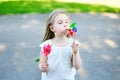 Adorable little girl in summer day holds windmill in hand Royalty Free Stock Photo