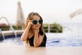 Adorable little girl at swimming pool in a swimsuit and sunglasses having fun during summer vacation Royalty Free Stock Photo