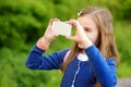 Adorable little girl taking a photo with a smartphone on beautiful summer day Royalty Free Stock Photo