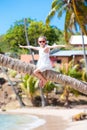 Happy kid sitting on palm tree during caribbean vacation on white beach Royalty Free Stock Photo