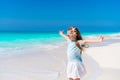 Adorable little girl walking along white sand Caribbean beach