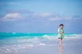 Adorable little girl walking along white sand caribbean beach