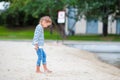 Adorable little girl walking along white sand near the lake Royalty Free Stock Photo