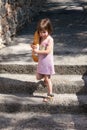 Adorable little girl walking and holding a loaf of bread