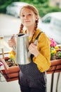 Adorable little girl watering plants on the balcony Royalty Free Stock Photo