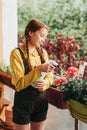 Adorable little girl watering plants on the balcony Royalty Free Stock Photo