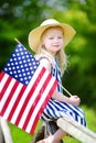 Adorable little girl wearing hat holding american flag outdoors on beautiful summer day Royalty Free Stock Photo