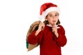 Adorable little girl wearing santa hat carrying gift bag Royalty Free Stock Photo