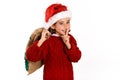 Adorable little girl wearing santa hat carrying gift bag Royalty Free Stock Photo