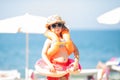 Adorable little girl wearing sunglasses, inflatable over-sleeves floats and inflatable donut float ring, sea coast at the Royalty Free Stock Photo