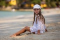 Adorable little girl at white beach during summer vacation,Cute little girl sitting alone on the beach looking at the sea,Travel Royalty Free Stock Photo