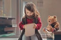 Adorable little girl, writing letter to Santa, sitting on a wind Royalty Free Stock Photo