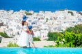 Adorable little girl and young mother in outdoor swimming pool background Mykonos town on Cyclades, Greece Royalty Free Stock Photo