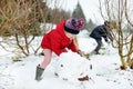 Adorable little girls building a snowman in the backyard. Cute children playing in a snow. Royalty Free Stock Photo