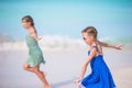 Adorable little girls have a lot of fun on the beach. Two beautiful kids running and splashing in shallow water Royalty Free Stock Photo