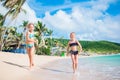 Adorable little girls have a lot of fun on the beach. Two beautiful kids running and splashing in shallow water Royalty Free Stock Photo