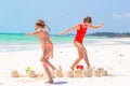 Adorable little girls during summer vacation. Kids playing with beach toys on the white beach Royalty Free Stock Photo