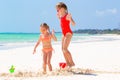 Adorable little girls during summer vacation. Kids playing with beach toys on the white beach Royalty Free Stock Photo