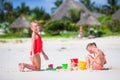 Adorable little girls during summer vacation. Kids playing with beach toys on the white beach Royalty Free Stock Photo