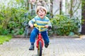 Adorable little kid boy driving his first bike or laufrad Royalty Free Stock Photo