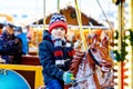 Adorable little kid boy riding on a merry go round carousel horse at Christmas funfair or market, outdoors. Happy child Royalty Free Stock Photo