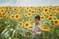 Adorable little kid boy on summer sunflower field outdoor. Happy child sniffing a sunflower flower on green field Royalty Free Stock Photo