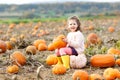 Adorable little kid girl having fun on pumpkin patch farm. Traditional family festival with children, thanksgiving and Royalty Free Stock Photo