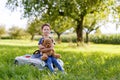 Adorable little kid girl sitting on big vintage old toy car and having fun with playing with big plush toy bear, Royalty Free Stock Photo