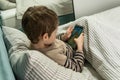 Adorable little kid using smartphone. Child playing video game Royalty Free Stock Photo