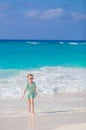 Adorable little kid walking along white sand caribbean beach