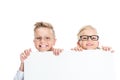 adorable little kids in eyeglasses holding blank banner and smiling at camera Royalty Free Stock Photo