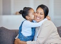 Adorable little mixed race girl kissing her mom on cheek while bonding at home. Loving, caring and affectionate mother Royalty Free Stock Photo