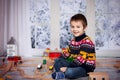 Adorable little preschool boy, playing with wooden trains and ra Royalty Free Stock Photo