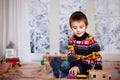 Adorable little preschool boy, playing with wooden trains and ra Royalty Free Stock Photo