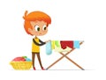 Adorable little redhead boy hanging washed clothes on drying rack isolated on white background. Home activity for kids