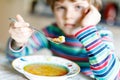 Adorable little school boy eating vegetable soup indoor. Royalty Free Stock Photo