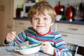 Adorable little school boy eating vegetable soup indoor. Royalty Free Stock Photo