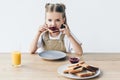 adorable little schoolgirl eating toast with jam