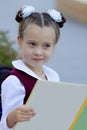 Adorable little schoolgirl reading book outdoors on the school yard. Educational concept. Royalty Free Stock Photo