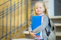 Adorable little schoolgirl studying outdoors on bright autumn day. Young student doing her homework. Education for small kids. Royalty Free Stock Photo