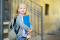 Adorable little schoolgirl studying outdoors on bright autumn day. Young student doing her homework. Education for small kids. Royalty Free Stock Photo