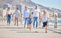 Adorable little sibling brother and sister running ahead on a seaside promenade on a sunny day. Multi-generation family Royalty Free Stock Photo